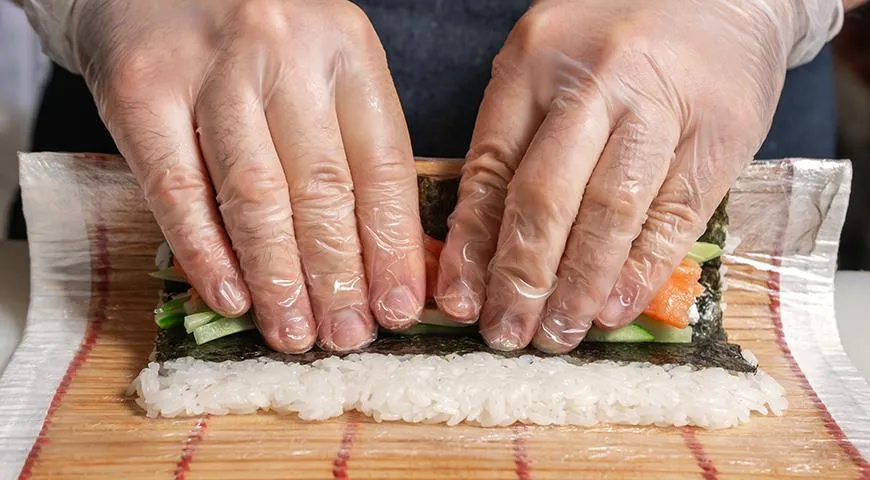 Do przygotowania bułek z ryżem w środku potrzebna będzie mata do sushi, folia spożywcza i arkusze nori