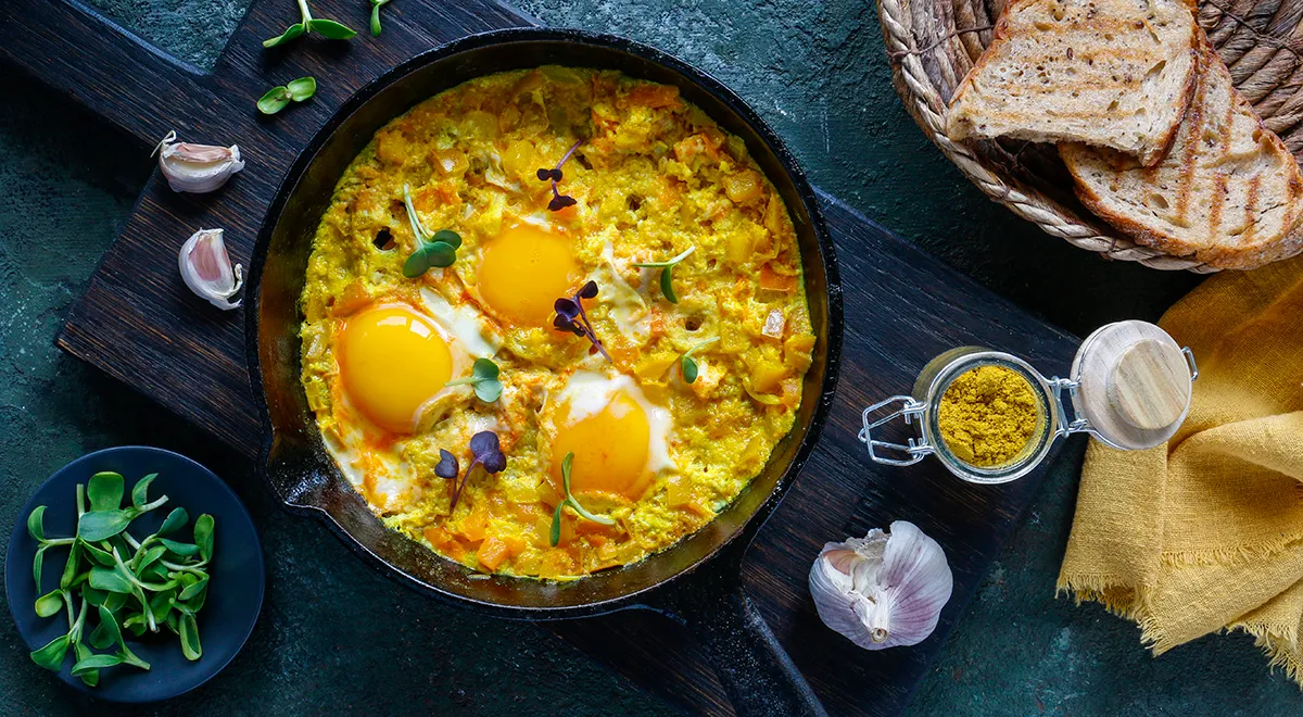 Żółta shakshuka z kurkumą na patelni